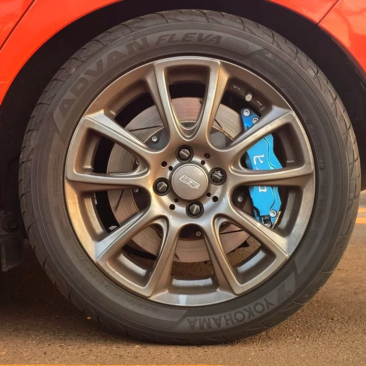 Caliper trasero azul de Yellow Speed Racing y rotor grande visibles detrás de un aro Mugen del Honda Fit.