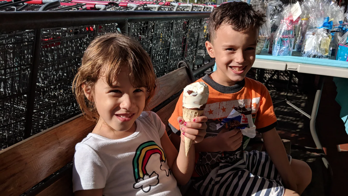 A brother and sister smile while eating ice cream together in Puerto Rico.